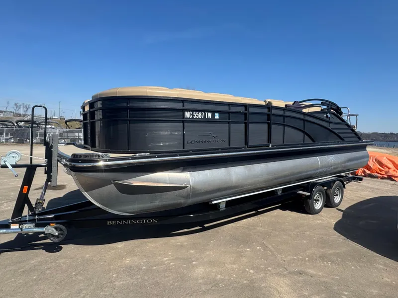 Slide: The Image of 2016 Bennington 2275 RCW pontoon boat on trailer, parked outdoors under clear blue sky. - 4