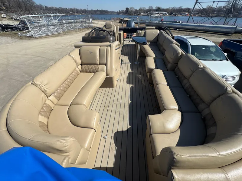 Slide: The Image of 2016 Bennington 2275 RCW pontoon boat with spacious beige seating and wood-style flooring. - 5