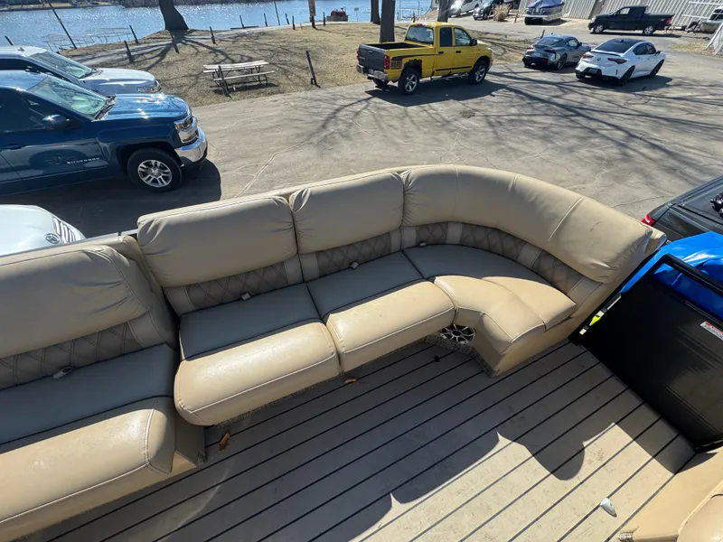 Slide: The Image of 2016 Bennington 2275 RCW boat with beige seating, parked near a waterfront. - 7
