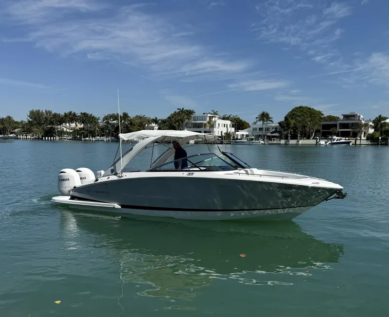 Slide: The Image of 2019 Regal 29 OBX boat cruising on a calm, scenic waterway. - 1