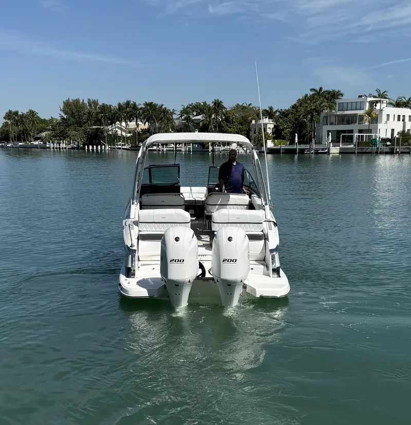 Slide: The Image of 2019 Regal 29 OBX boat cruising on a calm, scenic waterway. - 10