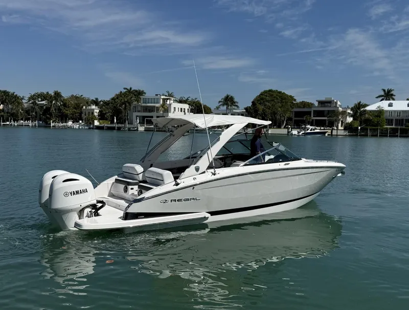 Slide: The Image of 2019 Regal 29 OBX boat on calm water with Yamaha outboard motor. - 12