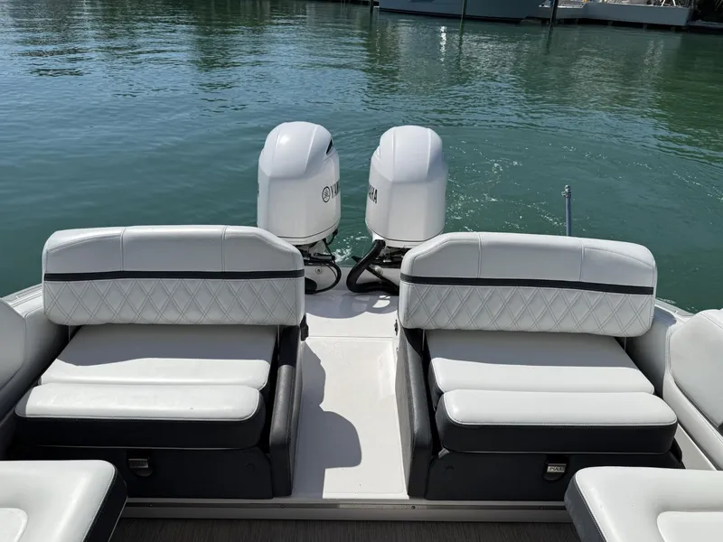 Slide: The Image of 2019 Regal 29 OBX boat with dual outboard engines and white seating on calm water. - 16