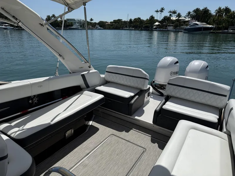 Slide: The Image of 2019 Regal 29 OBX boat interior with seating, on a calm waterfront. - 17