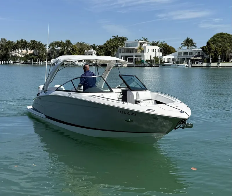Slide: The Image of 2019 Regal 29 OBX boat cruising on a calm, scenic waterway. - 2