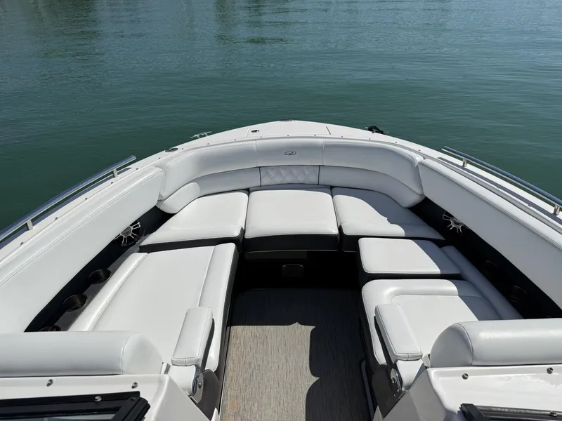 Slide: The Image of 2019 Regal 29 OBX boat with spacious white seating, docked on calm water. - 27