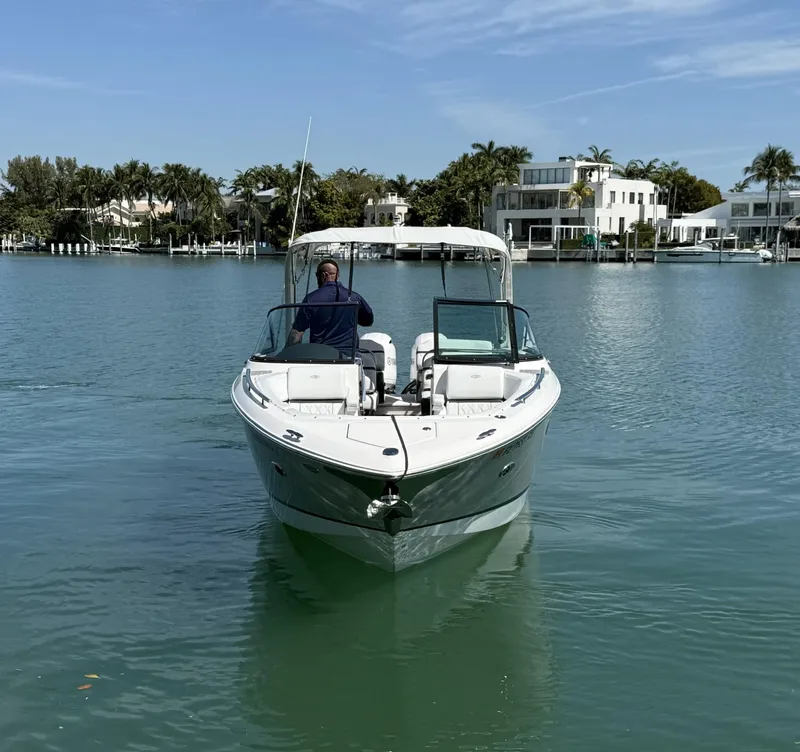 Slide: The Image of 2019 Regal 29 OBX boat cruising on a calm, scenic waterway. - 3