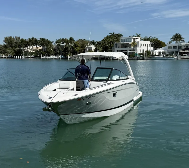 Slide: The Image of 2019 Regal 29 OBX boat cruising on calm waters near luxury waterfront homes. - 4