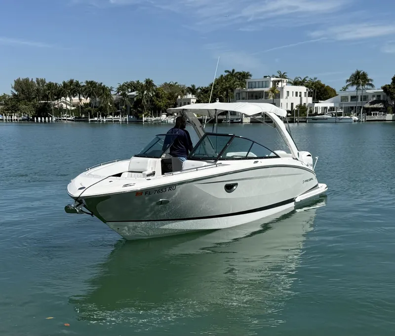 Slide: The Image of 2019 Regal 29 OBX boat cruising on calm waters near waterfront homes. - 5