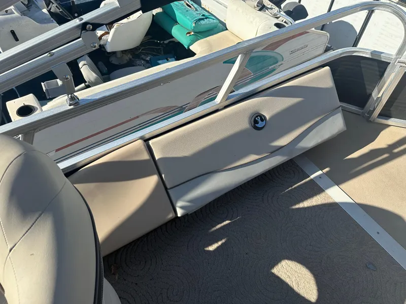 Slide: The Image of 2012 Sun Tracker Fishin' Barge 24 DLX interior with beige seating and storage compartment. - 10