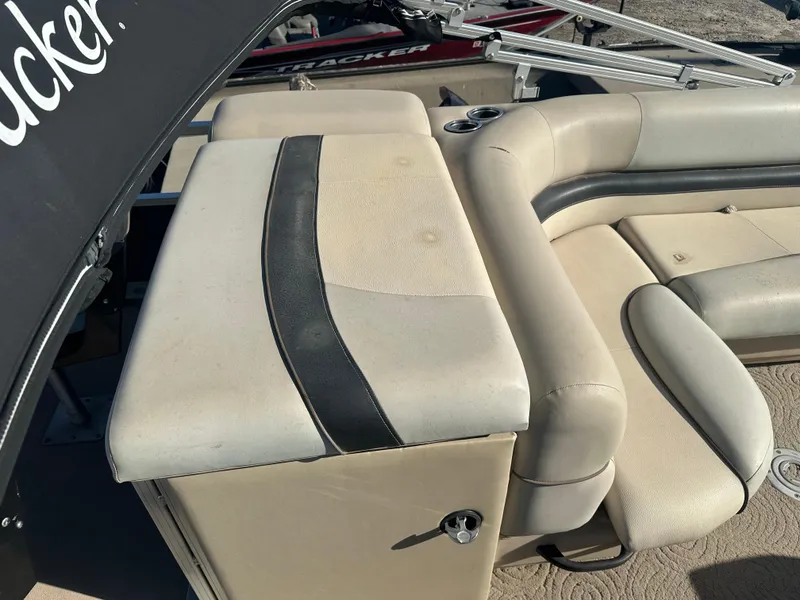 Slide: The Image of 2012 Sun Tracker Fishin' Barge 24 DLX boat interior with beige seating and storage. - 13