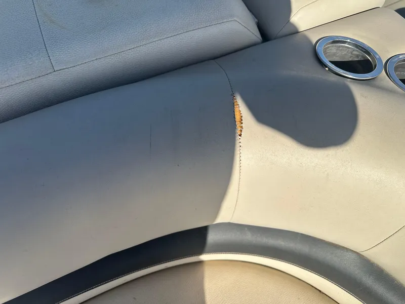 Slide: The Image of Torn upholstery on 2012 Sun Tracker Fishin' Barge 24 DLX boat seat with cup holders. - 16