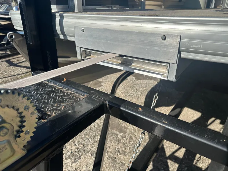 Slide: The Image of 2012 Sun Tracker Fishin' Barge 24 DLX trailer detail with metal components and textured surface. - 21