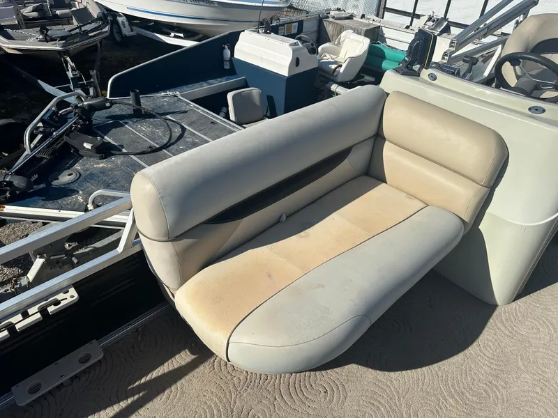 Slide: The Image of 2012 Sun Tracker Fishin' Barge 24 DLX boat seat, beige upholstery, outdoor setting. - 6