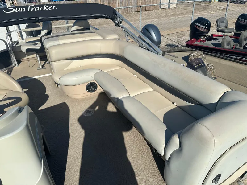 Slide: The Image of 2012 Sun Tracker Fishin' Barge 24 DLX with beige seating and spacious deck layout. - 7