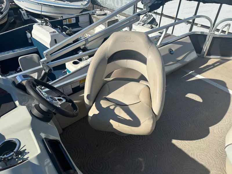 Slide: The Image of 2012 Sun Tracker Fishin' Barge 24 DLX boat interior with captain's chair and steering wheel. - 8