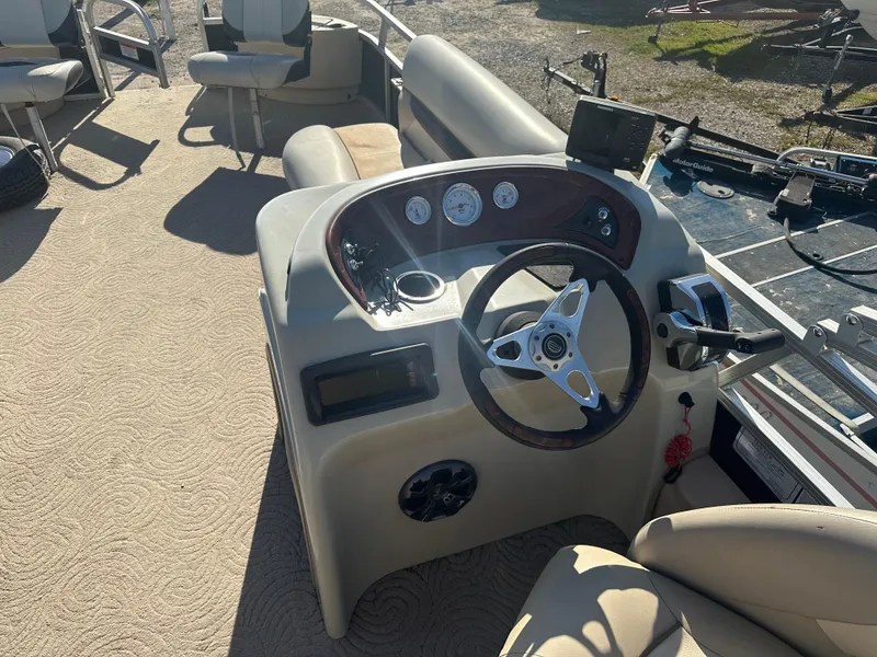 Slide: The Image of 2012 Sun Tracker Fishin' Barge 24 DLX boat console with steering wheel and gauges. - 9