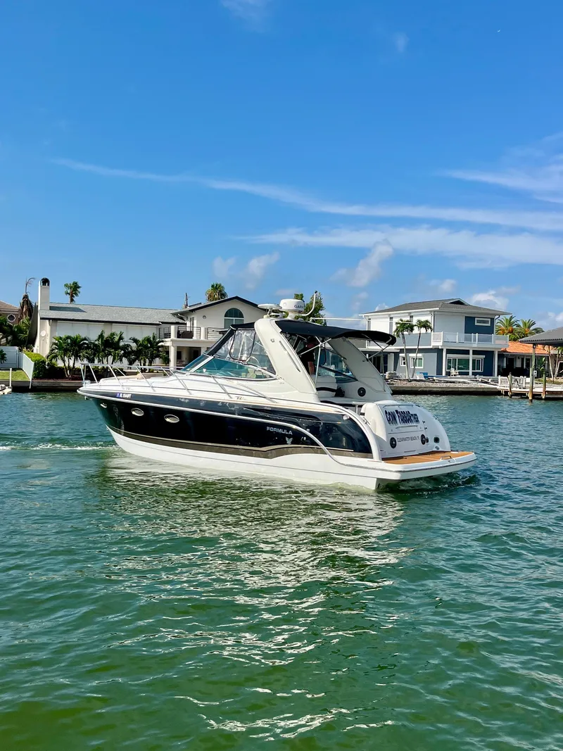 Slide: The Image of 2012 Formula 31 PC boat cruising on a sunny day near waterfront homes. - 11
