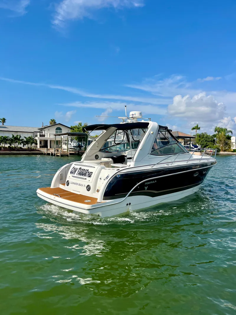 Slide: The Image of 2012 Formula 31 PC boat cruising on a sunny day in a scenic waterfront area. - 4