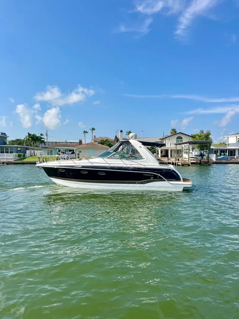 Slide: The Image of 2012 Formula 31 PC boat cruising on a sunny day near waterfront homes. - 9