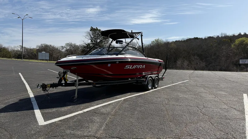 Slide: The Image of 2007 Supra Sunsport 22 V boat on trailer in parking lot, sunny day. - 7