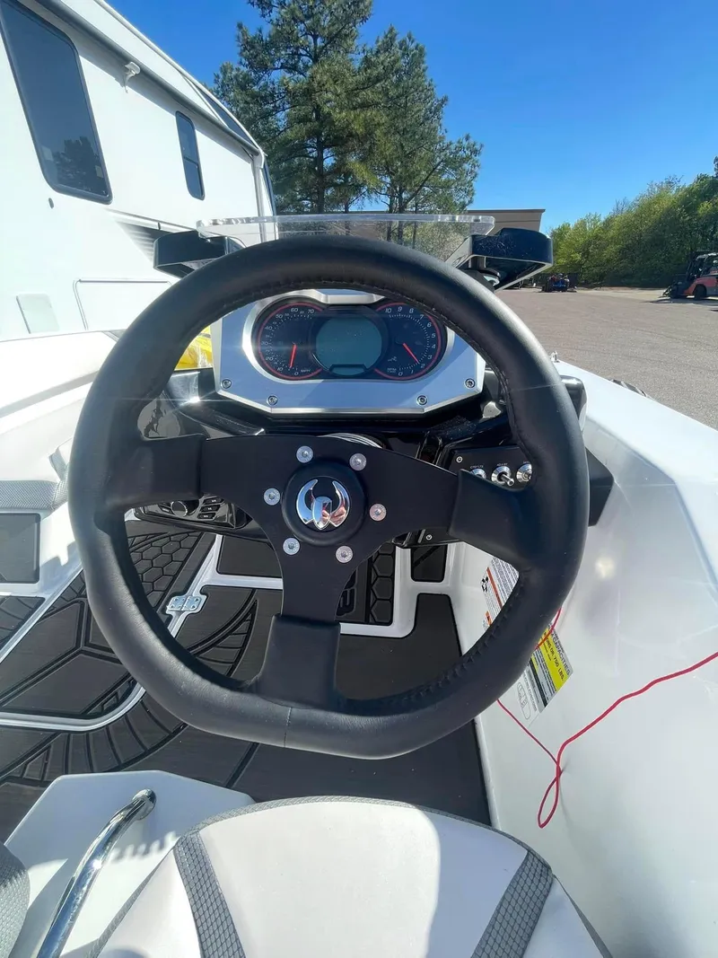 Slide: The Image of Steering wheel and dashboard of 2022 Scarab 165 SE boat under clear blue sky. - 5