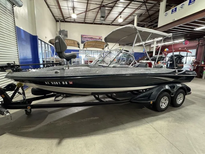 Slide: The Image of 2018 Ranger 212LS boat in showroom, featuring dual-axle trailer and canopy. - 2