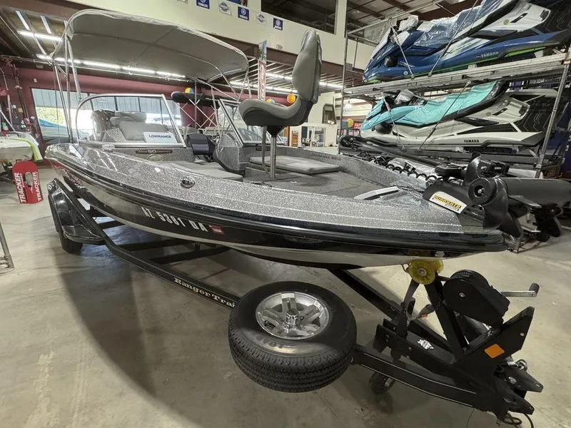 Slide: The Image of 2018 Ranger 212LS boat in showroom, featuring sleek design and trailer. - 20