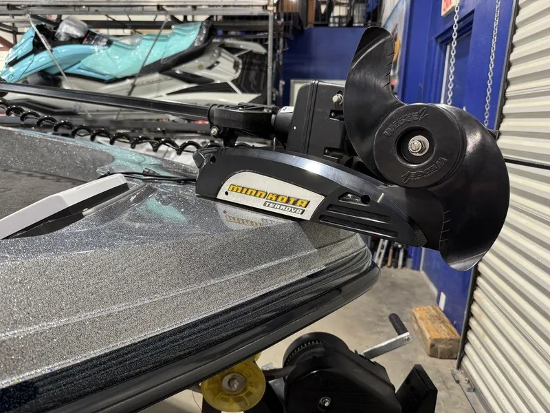 Slide: The Image of 2018 Ranger 212LS boat with Minn Kota trolling motor in a garage setting. - 25