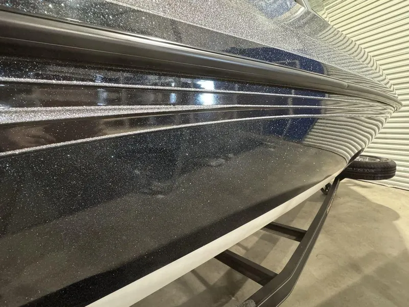 Slide: The Image of 2018 Ranger 212LS boat hull with metallic finish, displayed indoors. - 29