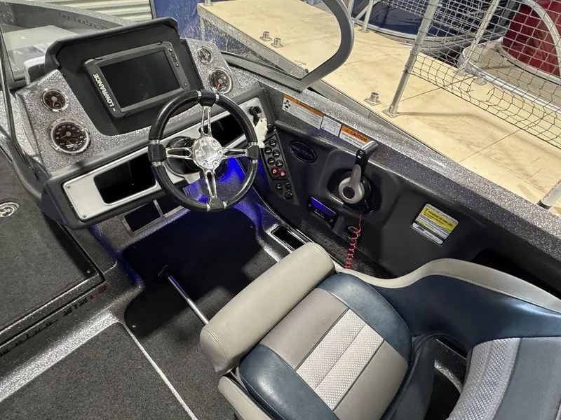 Slide: The Image of 2018 Ranger 212LS boat cockpit with steering wheel, control panel, and seating. - 48
