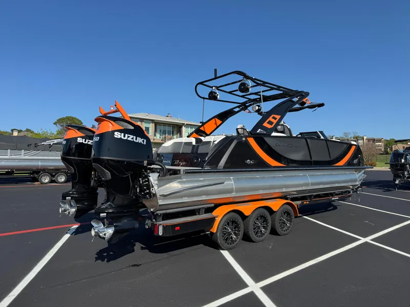 Slide: The Image of 2024 South Bay 25 Sport CR9-DC boat with dual Suzuki engines on a trailer. - 2