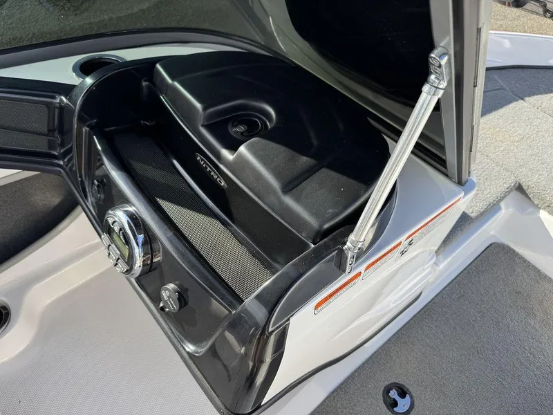 Slide: The Image of 2018 Nitro Z19 Sport boat storage compartment with open lid and latch mechanism. - 25
