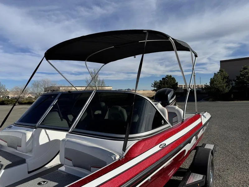 Slide: The Image of 2018 Nitro Z19 Sport boat with canopy, parked outdoors under a blue sky. - 7