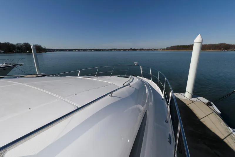 Slide: The Image of 2002 Sea Ray 480 Motor Yacht docked at a serene marina with clear blue skies. - 12