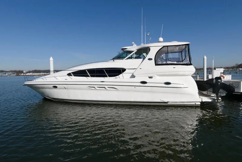 Slide: The Image of 2002 Sea Ray 480 Motor Yacht docked on calm water under clear blue sky. - 3