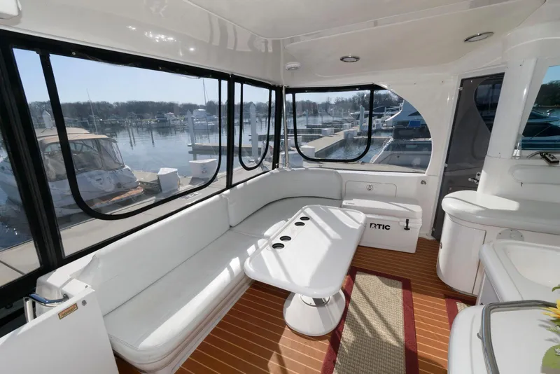 Slide: The Image of 2002 Sea Ray 480 Motor Yacht interior with white seating and marina view. - 7