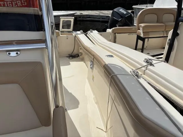 Slide: The Image of 2022 Scout 215 XSF boat interior with beige seating and deck, docked at marina. - 19