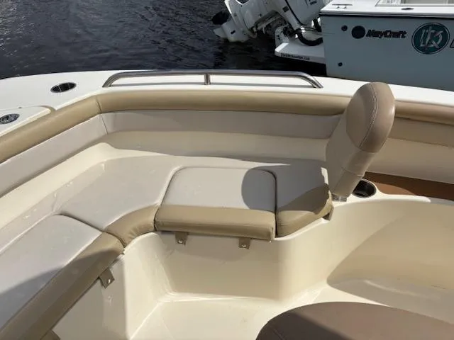Slide: The Image of 2022 Scout 215 XSF boat interior with beige seating and water backdrop. - 20