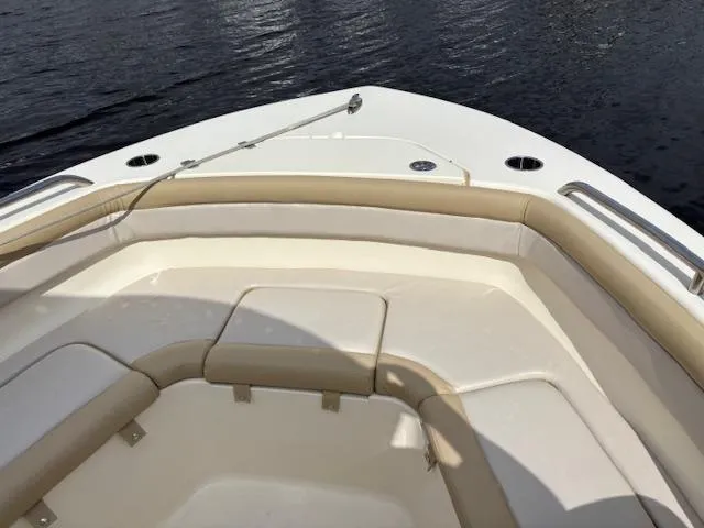 Slide: The Image of 2022 Scout 215 XSF boat bow with cushioned seating on calm water. - 22