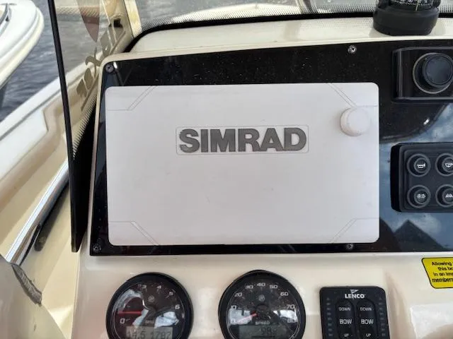 Slide: The Image of Simrad navigation system on 2022 Scout 215 XSF boat dashboard with gauges and controls. - 28