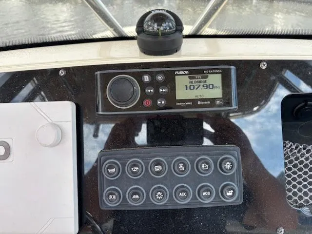 Slide: The Image of Control panel of 2022 Scout 215 XSF boat with radio and compass. - 29