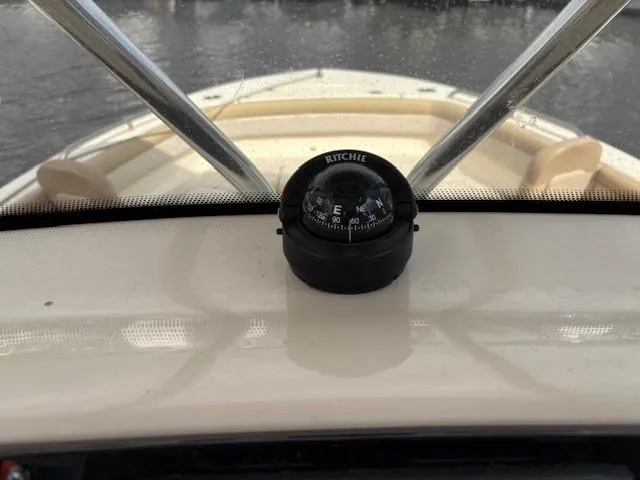 Slide: The Image of Compass on 2022 Scout 215 XSF boat dashboard, with water in the background. - 30