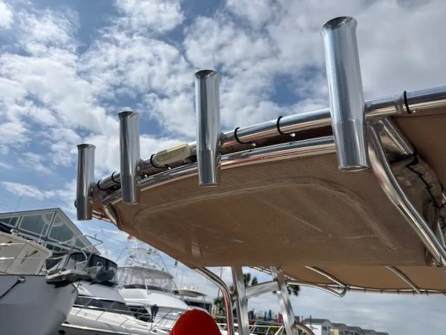 Slide: The Image of 2022 Scout 215 XSF boat with rod holders under a cloudy sky. - 32