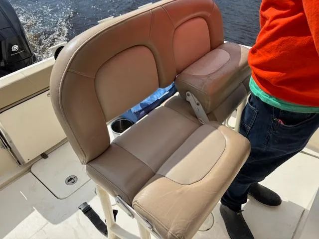 Slide: The Image of 2022 Scout 215 XSF boat with tan seating and person in red shirt. - 35