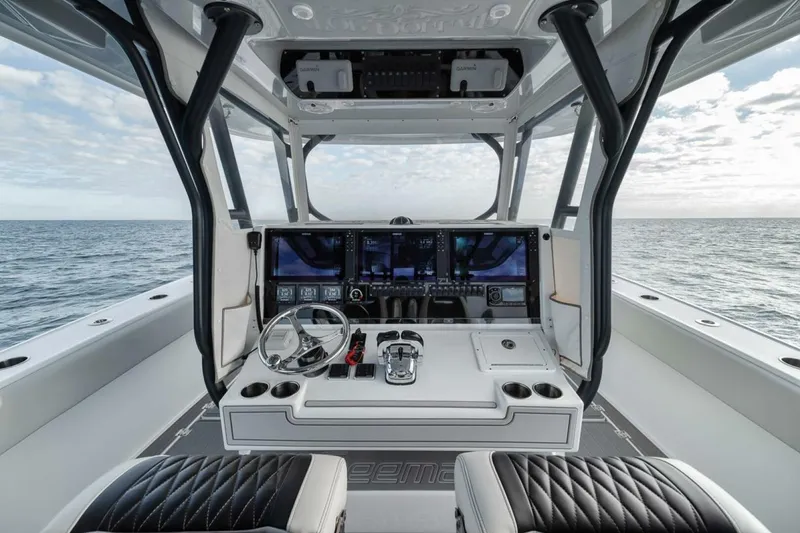 Slide: The Image of Cockpit of 2019 Freeman 42LR boat with advanced navigation system, steering wheel, and ocean view. - 23