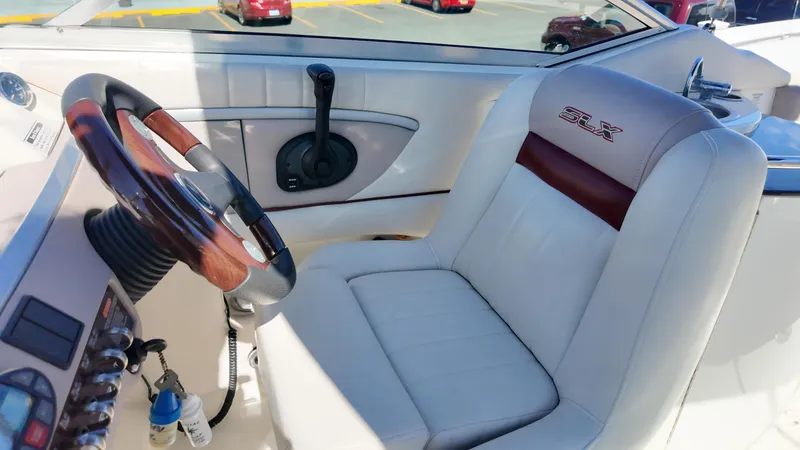 Slide: The Image of 2005 Sea Ray 270 Select EX boat cockpit with steering wheel and SLX-branded seat. - 13