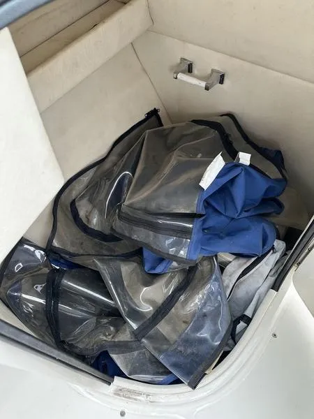 Slide: The Image of Storage compartment with clear and blue covers on a 2006 Sea Ray 220 Sundeck. - 19