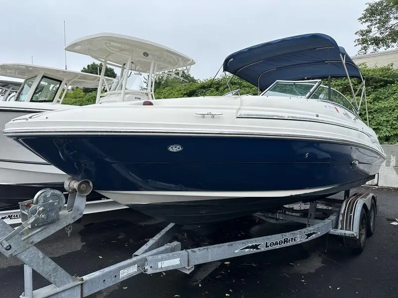 Slide: The Image of 2006 Sea Ray 220 Sundeck boat on trailer with blue and white exterior. - 3