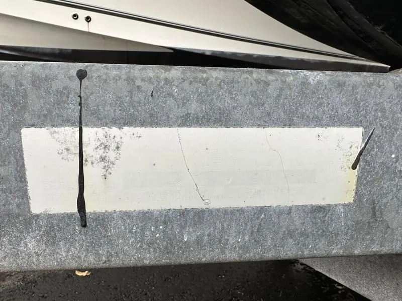 Slide: The Image of Close-up of a metal surface with paint drips, near a 2006 Sea Ray 220 Sundeck boat. - 6